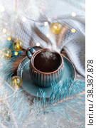 Coffee with foam in a beautiful blue cup on the background of a decorated Christmas tree. A ready-made Christmas or New Year greeting card. Стоковое фото, фотограф Оксана Медведева / Фотобанк Лори