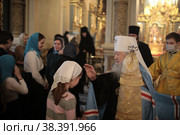 Митрополит Ювеналий благословляет ребёнка в Успенском храме Новодевичьего монастыря (2021 год). Редакционное фото, фотограф Дмитрий Неумоин / Фотобанк Лори