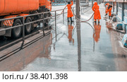 Russia, Samara, May 2017: Work janitors wash the sidewalk with a stream of water from a hose on the Moscow Highway on a spring sunny day. Стоковое фото, фотограф Акиньшин Владимир / Фотобанк Лори
