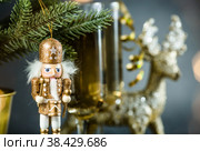 С Новым 2023 годом. Фон для рождественских и новогодних праздников с пространством для копирования. Игрушечный деревянный солдатик на рождественской елке и бокалы с шампанским на заднем плане. Стоковое фото, фотограф Photojuli / Фотобанк Лори