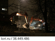 Москва, микрорайон Марфино, улица Академика Комарова, дом 8. Два эскаватора работают ночью на развалинах сносимого в рамках программы реновации дома. Рядом светится окно жилого дома (2022 год). Редакционное фото, фотограф Наталья Николаева / Фотобанк Лори