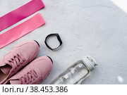 Здоровый образ жизни и фитнес. Спорт. Утренняя пробежка и занятия. Кроссовки, фитнес-резинки, умный фитнес-трекер, беспроводные наушники и бутылка воды на сером фоне. Вид сверху и плоское расположение. Стоковое фото, фотограф Photojuli / Фотобанк Лори