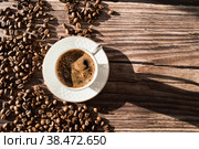 Кафе и рестораны. Кружка бодрящего черного кофе и кофейные зерна на деревянном фоне. Место для этикетки. Концепция горячих напитков. Стоковое фото, фотограф Photojuli / Фотобанк Лори
