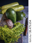 Haas California avocado zucchini thyme herbs and avocado green lie on a wooden table. Стоковое фото, фотограф Оксана Медведева / Фотобанк Лори