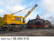 SORTAVALA, RUSSIA - OCTOBER 09, 2022: Railway crane KZh-462 "Pervomaets" loads coal old Soviet steam locomotive in Sortavala station on October morning. Редакционное фото, фотограф Виктор Карасев / Фотобанк Лори