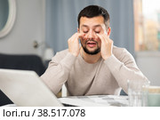 Man rubs tired eyes with his hands after a long work at laptop at home. Стоковое фото, фотограф Яков Филимонов / Фотобанк Лори