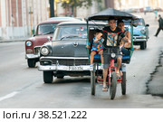 Куба. Гавана. Велорикша везет пассажиров по проезжей части. Cuba. Havana. A bicycle rickshaw carries passengers along the roadway. (2014 год). Редакционное фото, фотограф Алексей Смышляев / Фотобанк Лори