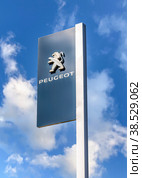 Official dealership sign of Peugeot against the blue sky (2019 год). Редакционное фото, фотограф FotograFF / Фотобанк Лори