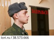 Россия. Санкт-Петербург. Солдат российской армии возле зеркала с надписью Заправься. Russia. Saint-Petersburg. A soldier of the Russian army near the mirror with the inscription Refuel. (2011 год). Редакционное фото, фотограф Алексей Смышляев / Фотобанк Лори