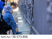 Россия. Санкт-Петербург. Виды Летнего сада. Ребенок рассматривает забор с барельефом изображения Медузы Горгоны. Russia. Saint-Petersburg. Types of Summer Garden. A child examines a fence with a bas-relief image of a Gorgon Medusa. (2021 год). Стоковое фото, фотограф Алексей Смышляев / Фотобанк Лори
