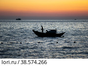 Вьетнам. Фукуок. Рыбалка. Рыбак на лодке ловит рыбу сетью. Vietnam. Phu Quoc. Fishing. Fisherman on a boat to catch fish with a net. (2017 год). Редакционное фото, фотограф Алексей Смышляев / Фотобанк Лори