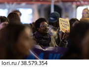 PORTUGAL, LISBON 11-25-2022: the March for the End of Violence Against Women - black woman holding by purple banner and holding a sign board in Portuguese. Редакционное фото, фотограф Константин Шишкин / Фотобанк Лори
