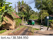 Шри-Ланка. Унаватуна. Транспорт тук-тук на железнодорожном переезде. Sri Lanka. Unawatuna. Transport tuk-tuk at a railway crossing. (2022 год). Редакционное фото, фотограф Алексей Смышляев / Фотобанк Лори