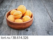 Ripe Golden apricots in wooden bowl on wooden background. Copy space. Стоковое фото, фотограф Оксана Медведева / Фотобанк Лори