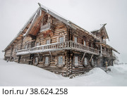 Россия, Карелия. Старинный дом Нестора Ошевнева в Кижах,  в февральскую пургу. (2022 год). Редакционное фото, фотограф Геннадий Соловьев / Фотобанк Лори