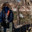 A grown man wearing a mask, wearing a hooded jacket, and wearing gloved military pants sits and looks into the camera. Стоковое фото, фотограф Владимир Арсентьев / Фотобанк Лори