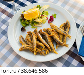 Dish with fried sardines, pilchards or anchovies in batter for traditional Spanish meal. Стоковое фото, фотограф Яков Филимонов / Фотобанк Лори