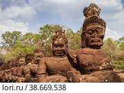 Stone figures of demons at the South Gate of the ancient city of Angkor Thom, Cambodia (2013 год). Стоковое фото, фотограф Юлия Бабкина / Фотобанк Лори