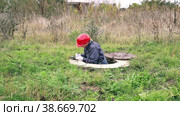 A plumber climbs out of a water well and records the water meter readings. Стоковое видео, видеограф Коханова Наталья / Фотобанк Лори