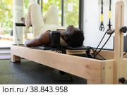 Activ middle-aged African-American man during pulling stretch band. Стоковое фото, фотограф Яков Филимонов / Фотобанк Лори