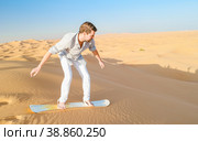 Young men sand surfing at the sand dunes of Dubai United Arab Emirates. Стоковое фото, фотограф Fokke Baarssen / Фотобанк Лори