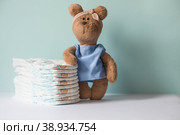 A stack of diapers and a stuffed teddy bear on the changing table. Love and care for the baby's skin. Space for text. Стоковое фото, фотограф Photojuli / Фотобанк Лори