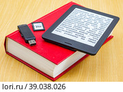 Карта памяти, флеш-накопитель, электронная и бумажная книги лежат на столе. Стоковое фото, фотограф Анна Аникова / Фотобанк Лори