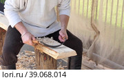 The carpenter processes a wooden beam with a chisel, makes a smooth wooden surface. High quality FullHD footage. Стоковое видео, видеограф Egor Sarantstv / Фотобанк Лори