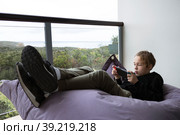 Lazy teenager spending leisure on playing console games. Стоковое фото, фотограф Данил Руденко / Фотобанк Лори