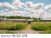 June 8, 2015 - Scene from a Russian village overlooking a colorful log house with traditional wood trim, Mandrogi, Russia. Редакционное фото, фотограф Оксана Медведева / Фотобанк Лори