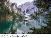 Wooden rowing boats at calm lake Braies or Pragser Wildsee during sunset pink light. Dolomites, Italy. Стоковое фото, фотограф Igor Tichonow / Фотобанк Лори