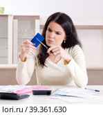 Young woman with receipts in budget planning concept. Стоковое фото, фотограф Elnur / Фотобанк Лори