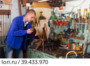 Gunsmith repairs butt of a shotgun in weapons workshop. Стоковое фото, фотограф Яков Филимонов / Фотобанк Лори