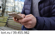 Мобильный телефон в мужских руках. Молодой человек, использует смартфон для инвестиций, денежных операций и онлайн-банкинга. Мужчина покупает акции, облигации, драгоценные металлы через интернет. A mobile phone in men's hands. A young man uses a smartphone for investments, money transactions and online banking. A man buys stocks, bonds, precious metals via the Internet. Стоковое видео, видеограф Ирина / Фотобанк Лори