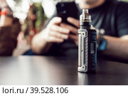 Vape stands on a wooden table in cafe. Стоковое фото, фотограф Сергей Толмачёв / Фотобанк Лори