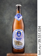 ORYOL, RUSSIA - APRIL 23, 2020: Bottle of Bavarian light wheat unfiltered Hofbraeu beer. Brewery founded on 27 September 1589. Редакционное фото, фотограф Сергей Чайко / Фотобанк Лори