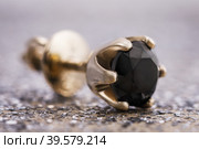 Beautiful gold earrings with a black diamond on the table, close-up (2019 год). Редакционное фото, фотограф Сергей Чайко / Фотобанк Лори