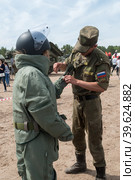 Girl - visitor of show puts on sapper suit (2016 год). Редакционное фото, фотограф Сергей Буторин / Фотобанк Лори
