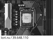 Maykop, Russia - November 9, 2018: intel core I3 desktop processor 8th gen and DDR 4 DIMM Kingston HyperX Fury Memory RAM Module in the slot on motherboard Asus closeup top view, black white photo. Редакционное фото, фотограф Андрей С / Фотобанк Лори