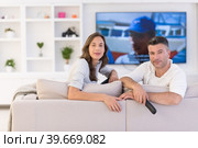 Young couple on the sofa watching television. Стоковое фото, фотограф Benis Arapovic / PantherMedia / Фотобанк Лори