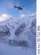 rescue team with a red helicopter rescuing a hurt skier. Стоковое фото, фотограф Benis Arapovic / PantherMedia / Фотобанк Лори