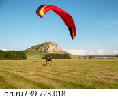 Мотопараплан с пилотом и пассажиром совершает взлёт. A paramotor with a pilot and a passenger takes off. (2022 год). Редакционное фото, фотограф Евгений Романов / Фотобанк Лори