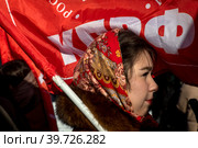 Участница митинга партии КПРФ приуроченного ко Дню защитника Отечества на площади Революции в центре города Москвы, Россия (2023 год). Редакционное фото, фотограф Николай Винокуров / Фотобанк Лори