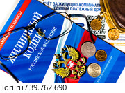 Брошюра с Жилищным кодексом Российской Федерации, платежка за коммунальные услуги и кошелек с мелочью на белом фоне (2023 год). Редакционное фото, фотограф Николай Винокуров / Фотобанк Лори