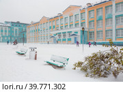 Школьники идут в школу, Анадырь, Чукотка, Крайний Север России. 7 октября. Холодная снежная погода. Заснеженная улица после снегопада. Дети идут к зданию школы. Школьное образование в Арктике. Редакционное фото, фотограф Андрей Степанов / Фотобанк Лори