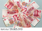 Paper money in denominations of 100 yuan are laid out in a circle on a light table. Chinese economy and finance. Currency background. The concept of finance, banking, investment, business and lending. Стоковое фото, фотограф Виктория Катьянова / Фотобанк Лори