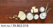 Rustic still life with fresh dairy products - milk, cottage cheese, yogurt, sour cream, butter and oat ears on old wooden table. Organic farm natural food. Place for text. Banner. Flat lay, copy space, mock up. Стоковое фото, фотограф Виктория Катьянова / Фотобанк Лори