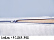 Orthopedic mattress with removable cover. Hand unzips the zipper close-up. Copy space. Стоковое фото, фотограф Кутина Татьяна / Фотобанк Лори