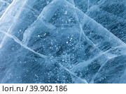 Beautiful winter natural ice texture of frozen Baikal Lake in cold February day. Blue ice surface with pattern of white cracks and bubbles. Natural background, mock up, copy space, flat lay, blank, close-up. Стоковое фото, фотограф Виктория Катьянова / Фотобанк Лори