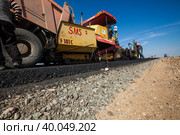 Kyzylorda province, Kazakhstan, April 29, 2012: Construction of West Europe-West China new road. Asphalt hopper of Dynapac road machine and road layers. Стоковое фото, фотограф Alexey Rezvykh / Фотобанк Лори